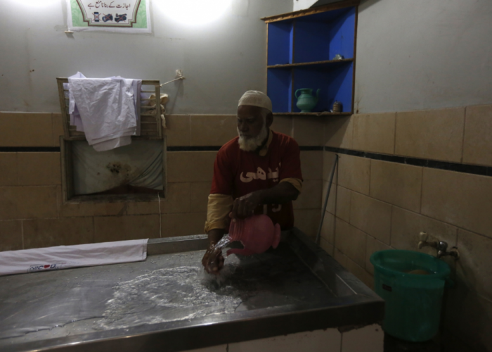 Latafat Hussain washes an autopsy table at the Edhi Foundation mortuary.